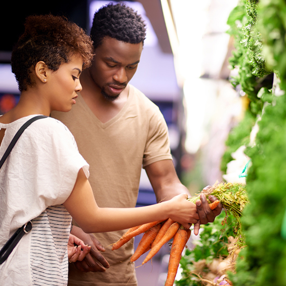 People examining fresh carrots